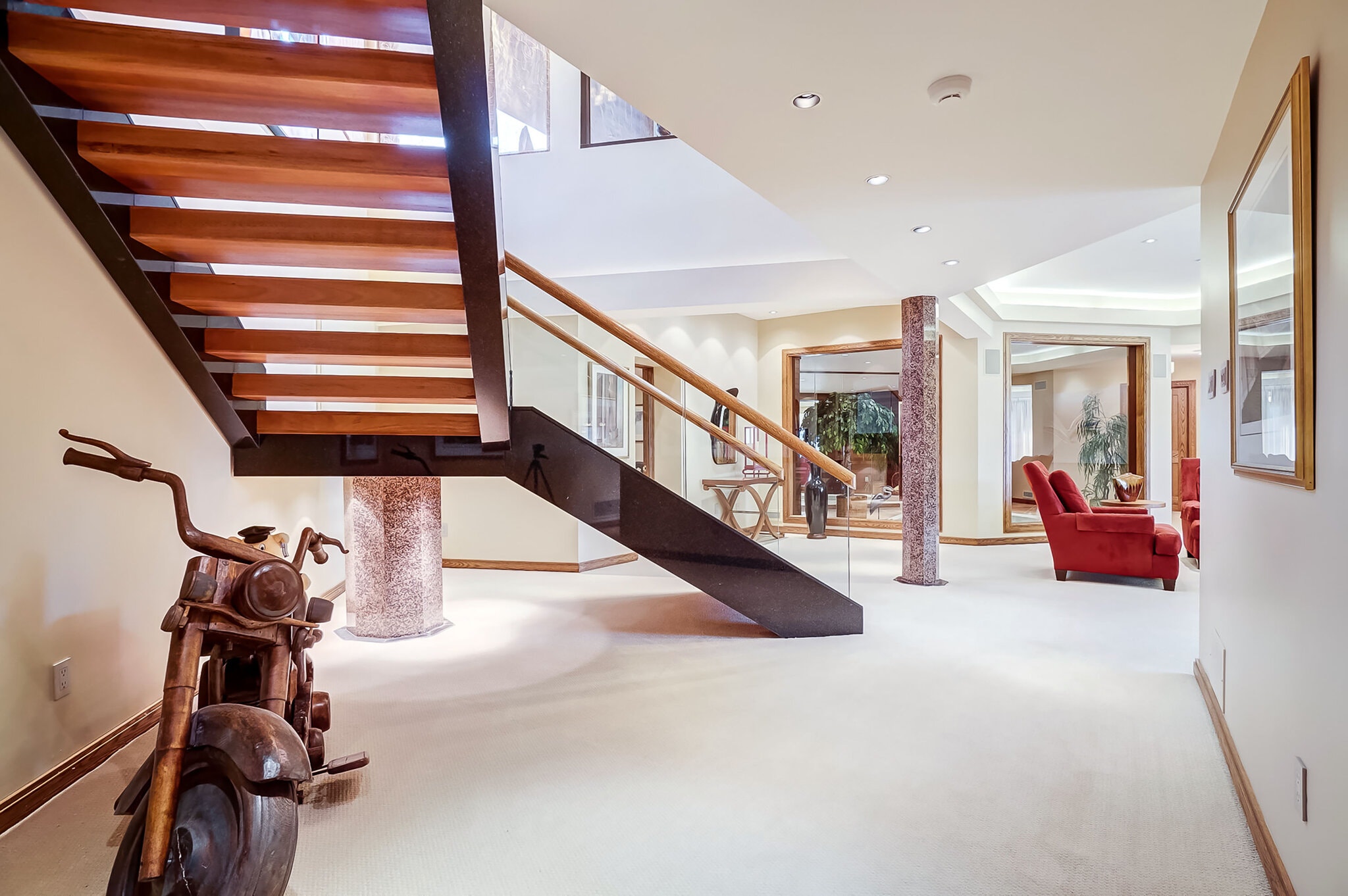 A floating staircase leads down to the lower level, which has a media room, wet bar and gym. Tall glass doors open to expansive green space and vistas of the Rideau River.